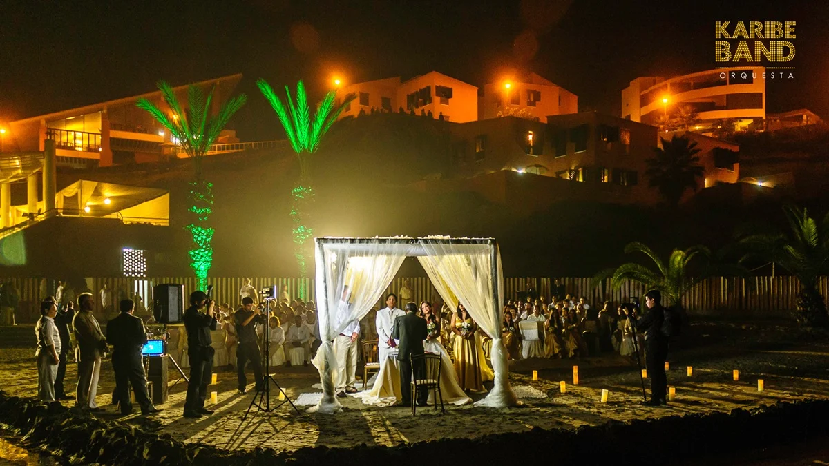 Ceremonia de boda en la playa en Lima de noche con decoración iluminada y orquesta Karibe Band en vivo