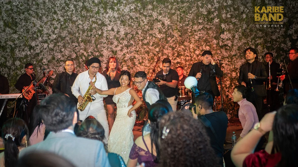 Orquesta en vivo animando boda en Lima con novios bailando y músicos en escenario durante celebración